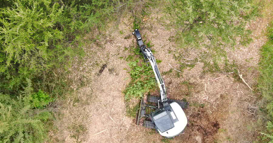 excavator with drum mulcher mulching trees